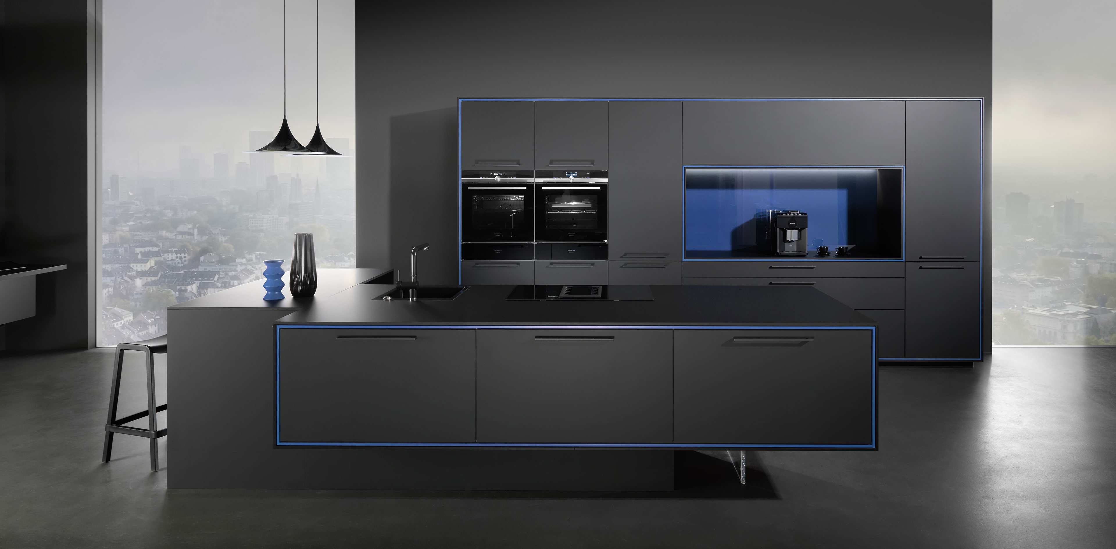 Rational Nautic: schwarze Küche mit Insel, eingebauten Backöfen und blauer Akzentbeleuchtung